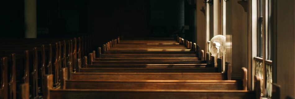 brown wooden church bench near white painted wall